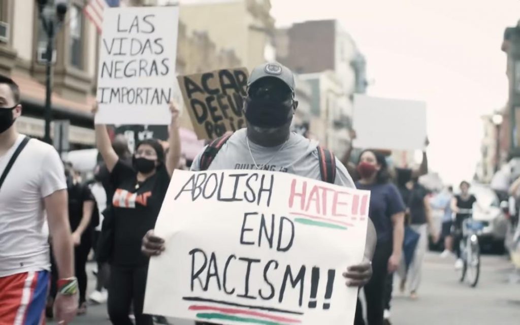 Cartaz com os dizeres: "Abolição ao ódio e ao racismo". Crédito: NBC News/ Reprodução.